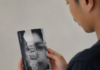 Senjata Terakhir Menghadapi Genosida Gaza Seorang pria terlihat dari sisi belakang sedang membaca buku kecil bercover hitam putih bertuliskan Minor Detail karya Adania Shibli. Wajah pria hanya tampak sebagian dalam posisi profil.